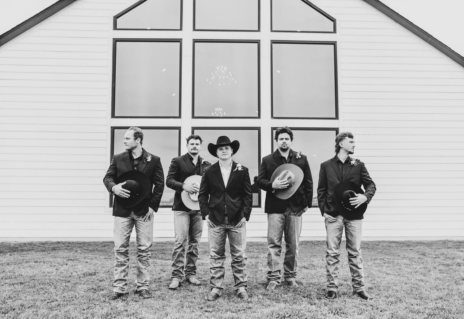 Groomsmen wearing cowboy hats boots and jeans at Texas wedding