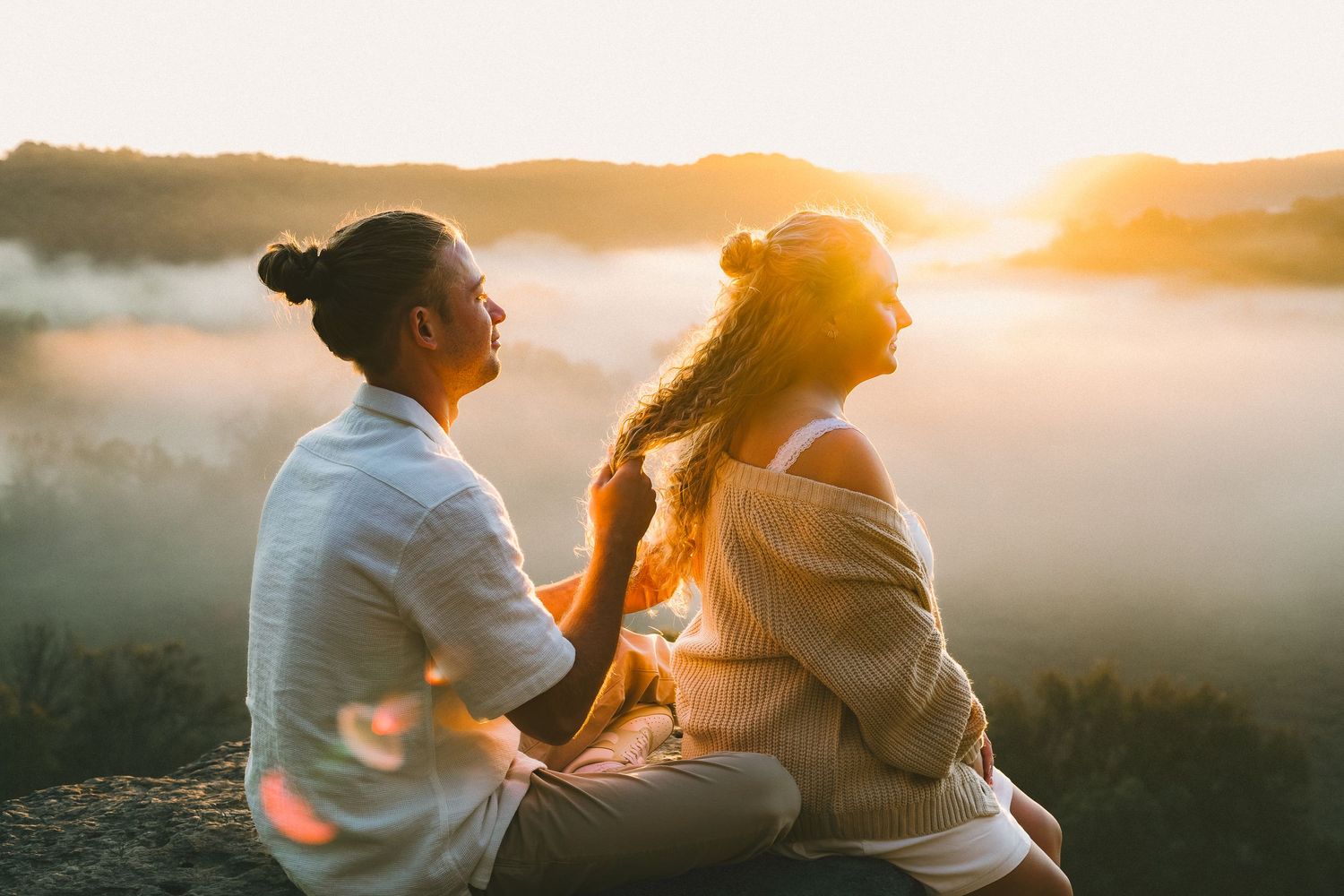 Couple sharing a joyful moment reflected in a round mirror, captured by a photographer at their wedding reception.