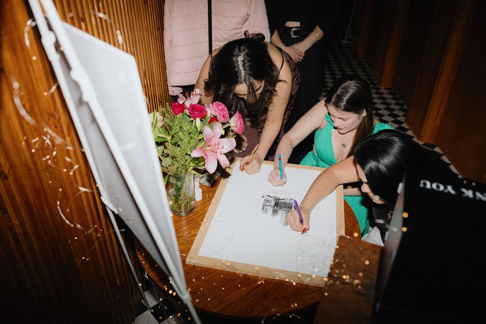 Wedding guests signing the card for the bride and groom at a wedding reception in Manchester