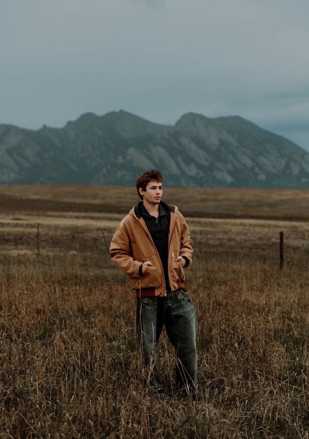 Boy stands, and poses for senior photos, cinematic, mountain, and portrait photos in Boulder, Colorado outside and in nature