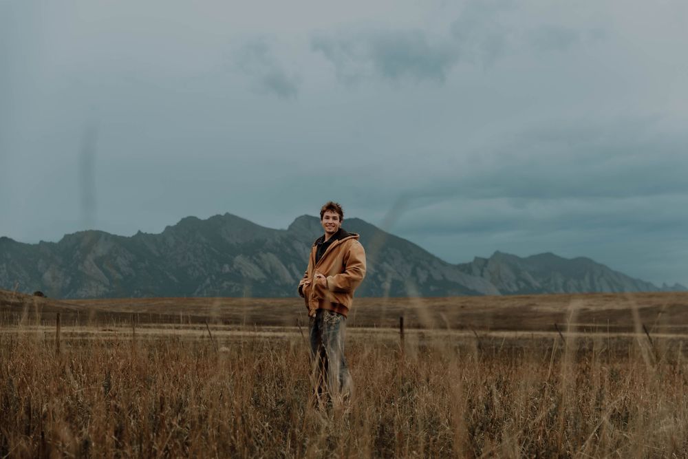 Boy stands, and poses for senior photos, cinematic, mountain, and portrait photos in Boulder, Colorado outside and in nature