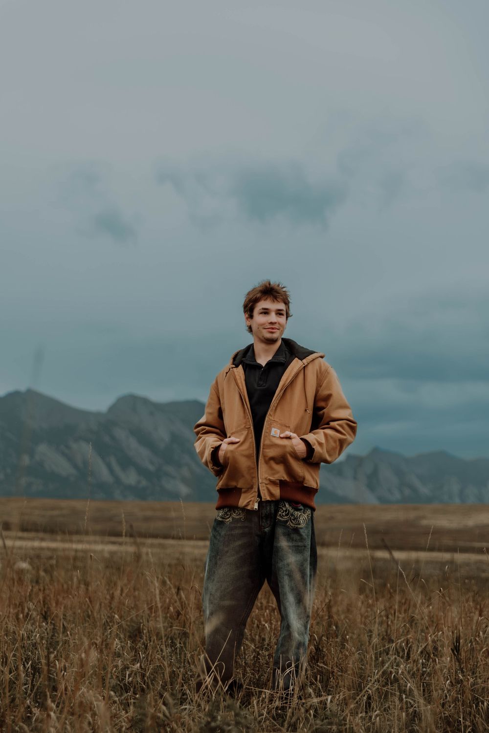 Boy stands, and poses for senior photos, cinematic, mountain, and portrait photos in Boulder, Colorado outside and in nature