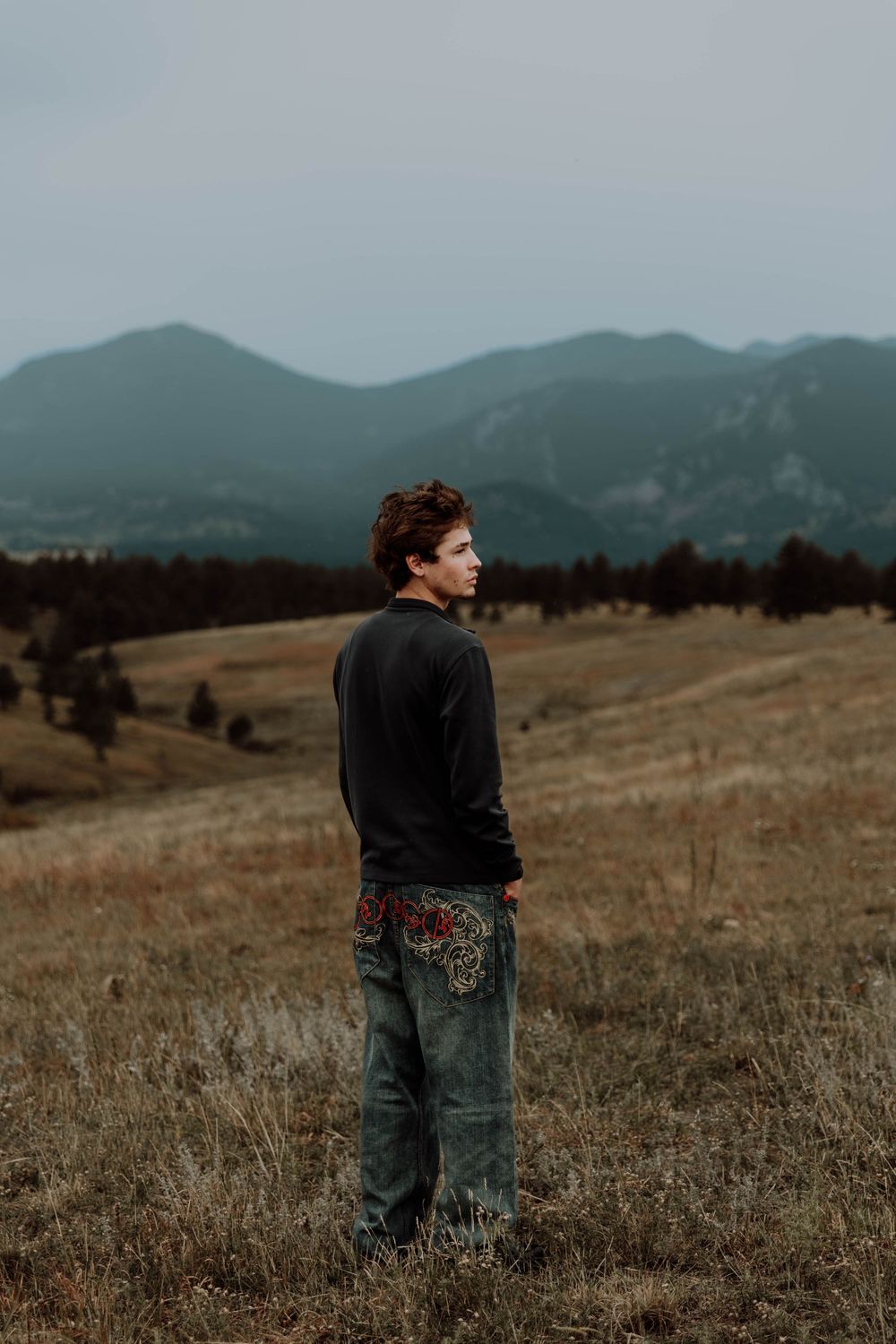 Boy stands, and poses for senior photos, cinematic, mountain, and portrait photos in Boulder, Colorado outside and in nature