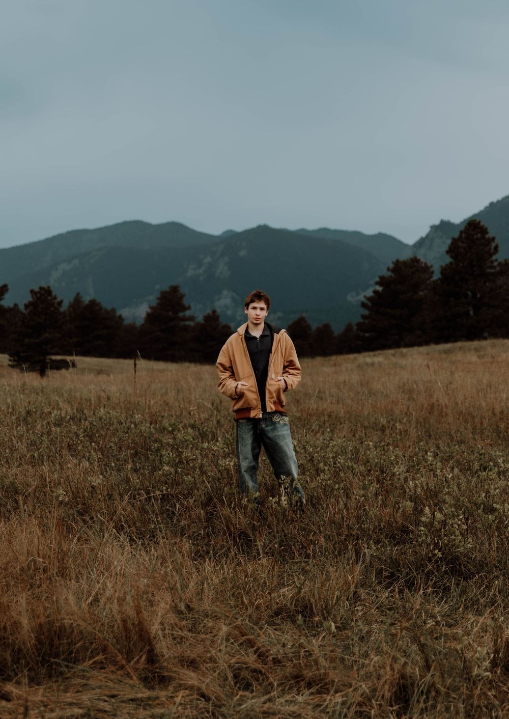 Boy stands, and poses for senior photos, cinematic, mountain, and portrait photos in Boulder, Colorado outside and in nature