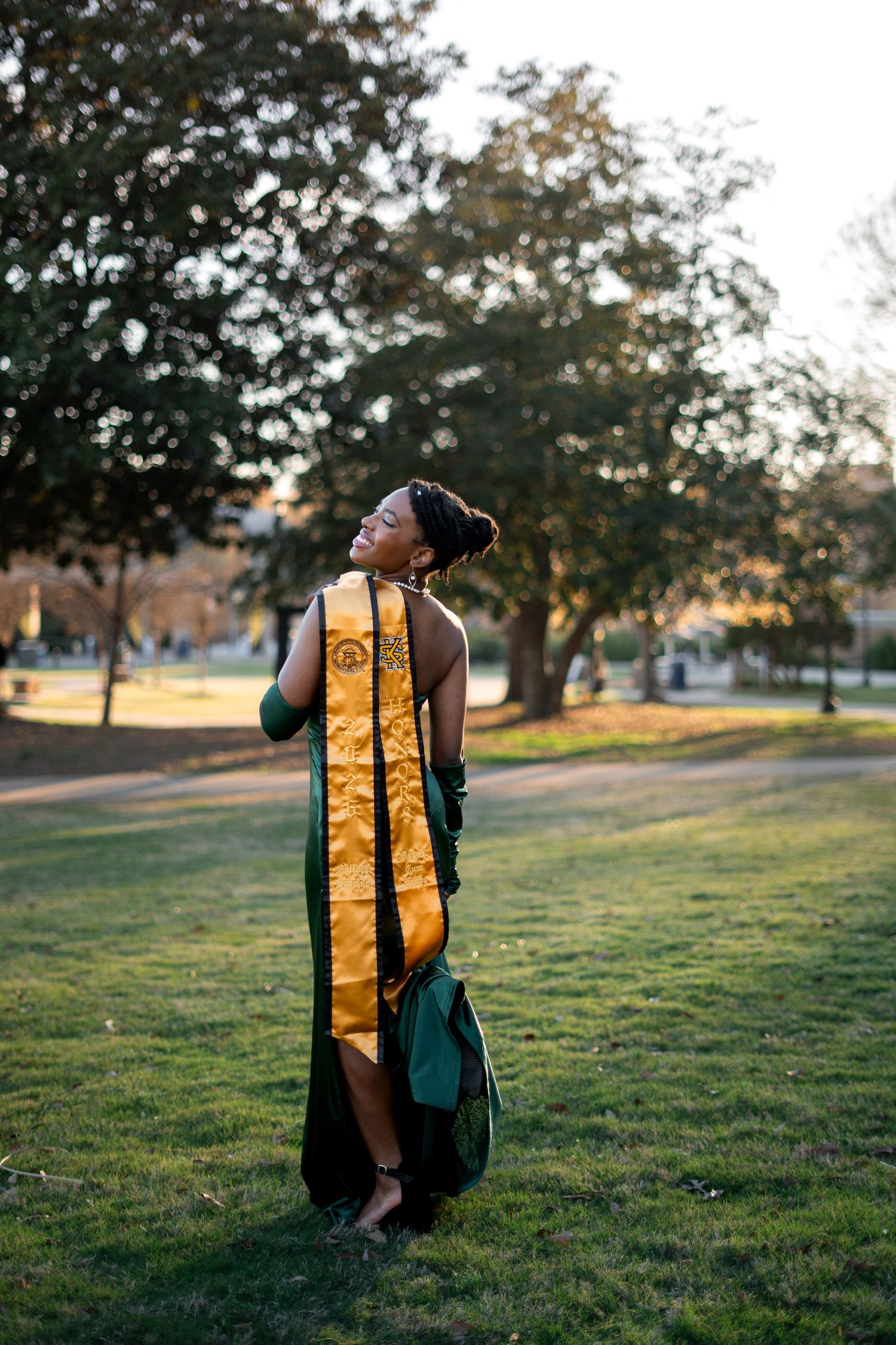 Smiling graduate poses for the best Atlanta grad photos at Kennesaw State University KSU with portraits by Pierre The Pear Photography