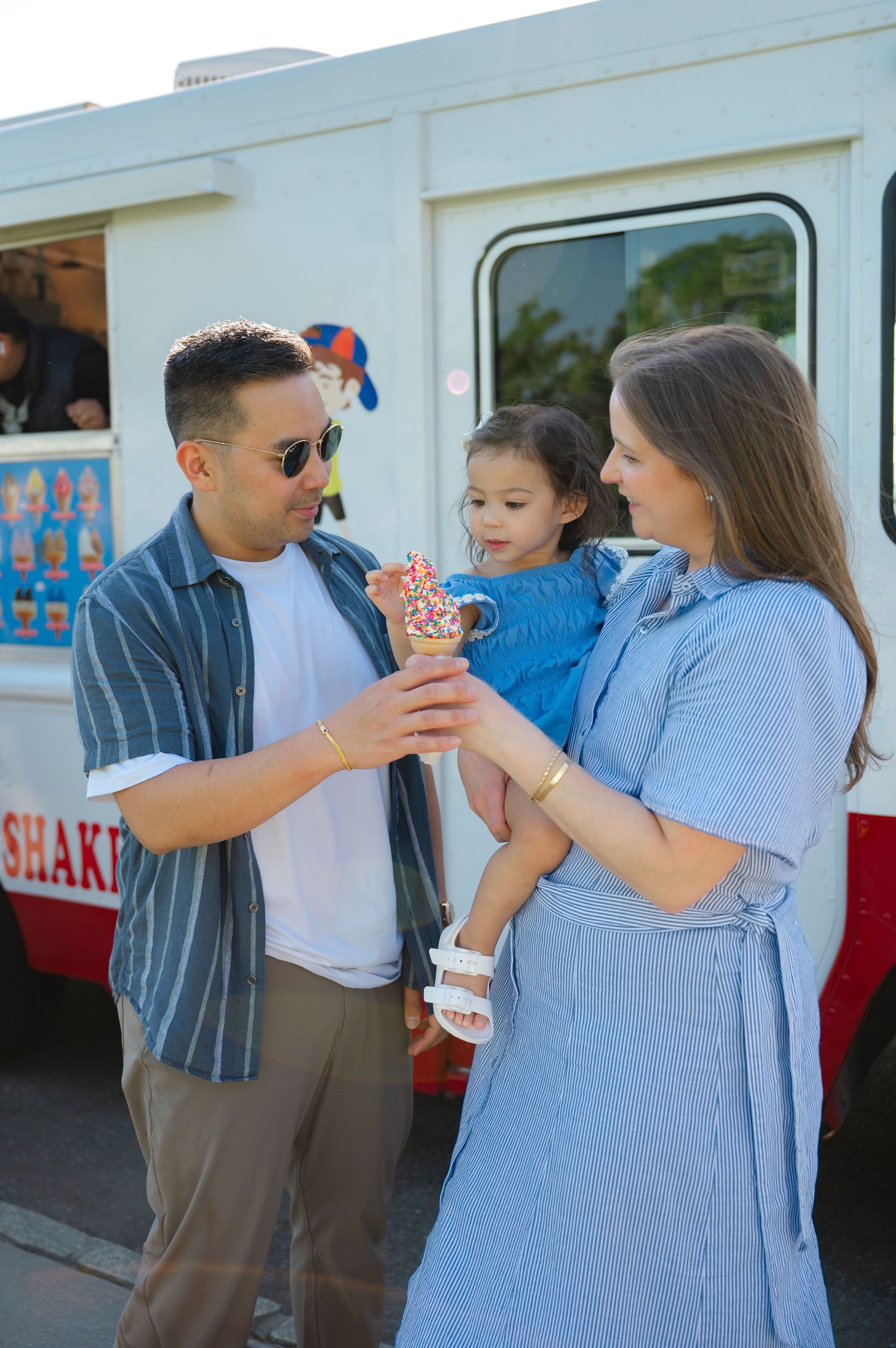 Family enjoying ice cream cones together in front of an ice cream truck on a sunny day in Tarrytown, NY during a family photo session.