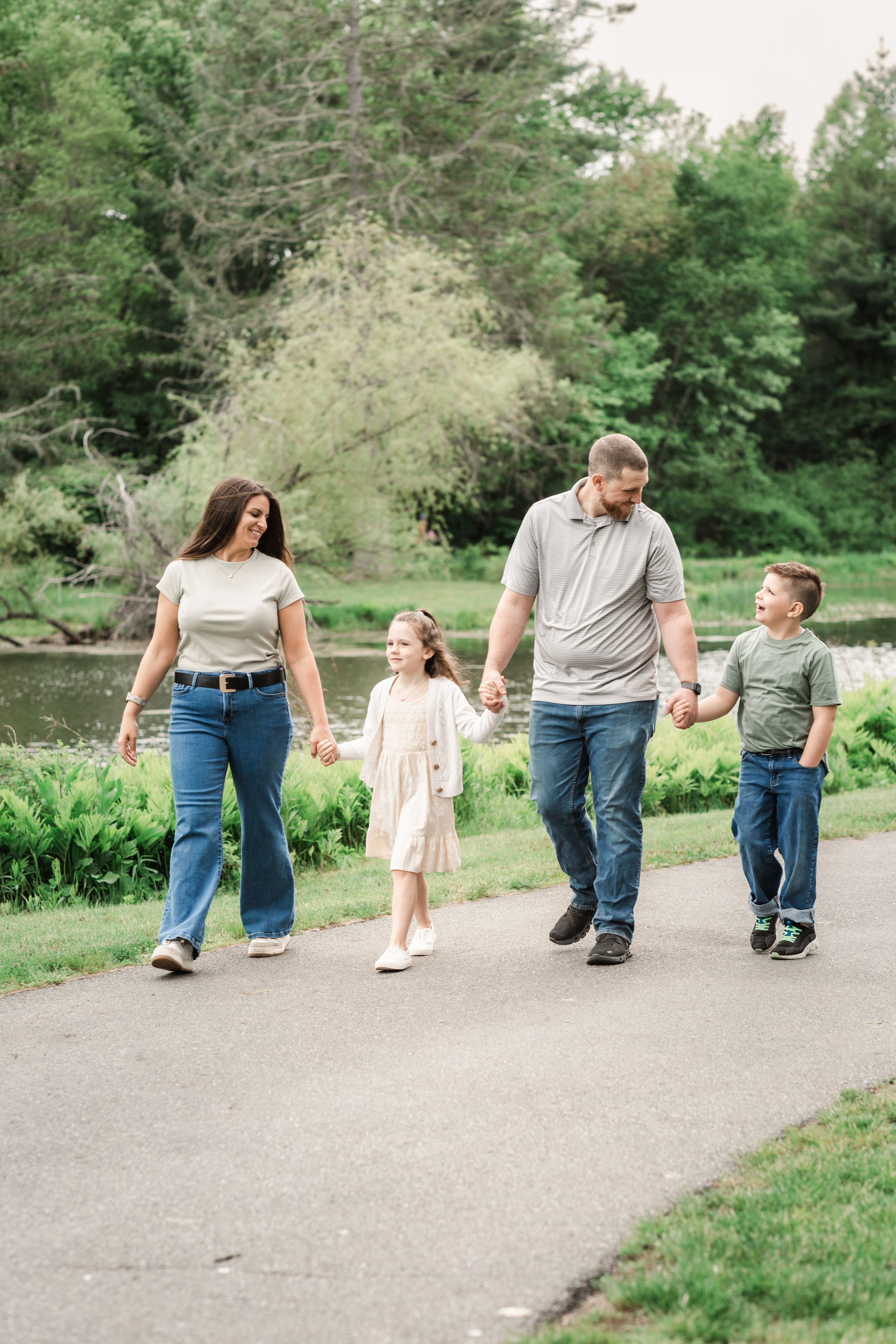 family walking together in family session park in southern NH around pond