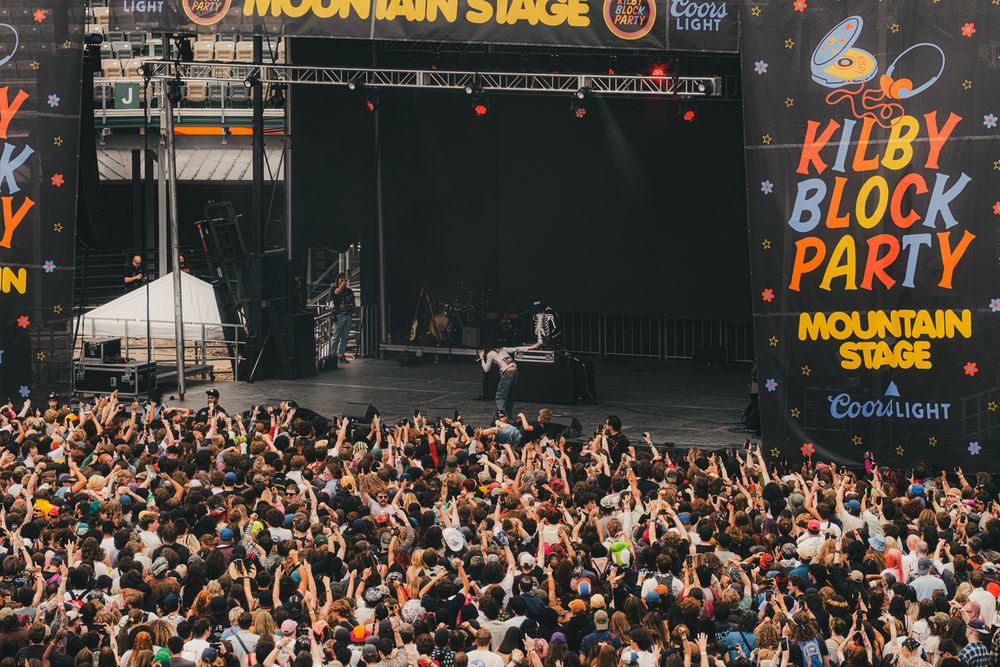 Crowd at Kilby Block Party Mountain Stage sponsored by Coors Light, with fans raising hands before a live performance.