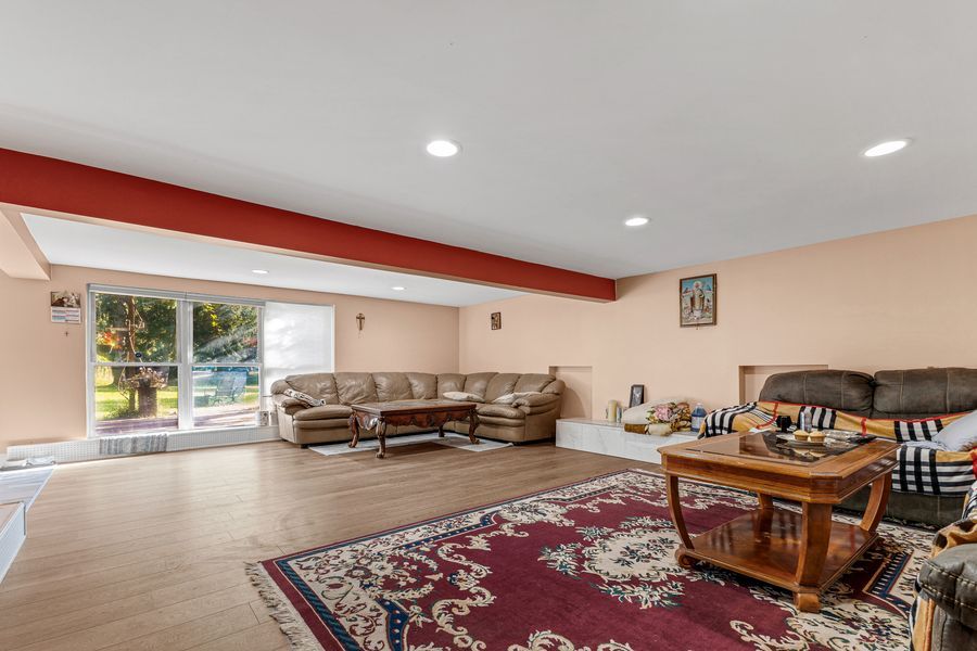 Spacious living room with hardwood floors, recessed lighting, and large sliding glass doors.