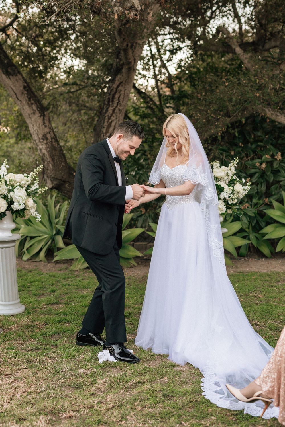 Groom steps on glass bottle to signify end of wedding ceremony in santa barbara wedding reception