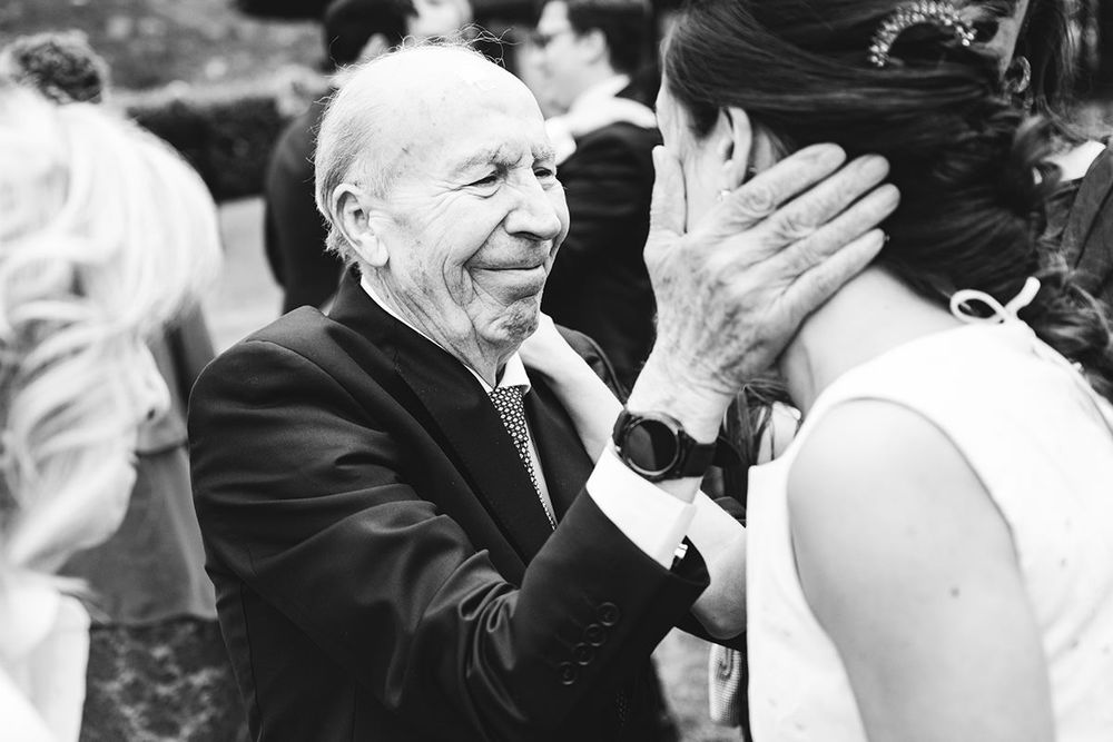 Abuelo abrazando a su nieta durante la celebración de una boda en Asturias.
