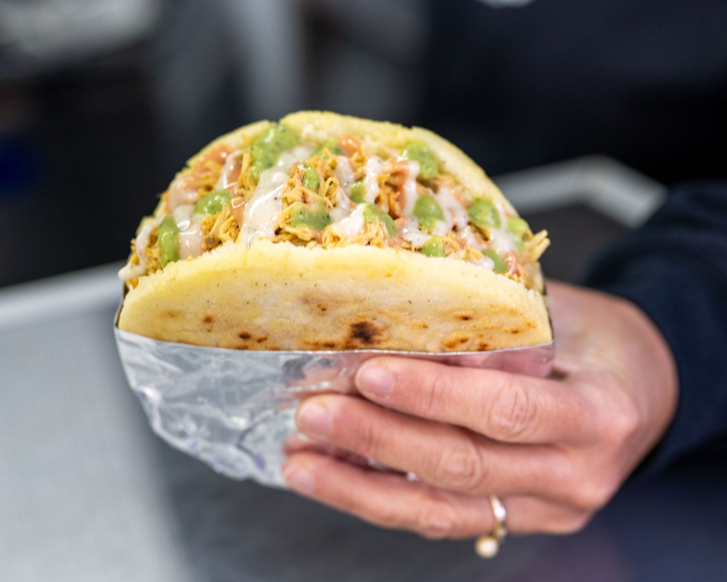 Branding session for Cali Arepa foodtruck based in Manchester, NH. Photo is a stuffed, Colombian arepa with sauces drizzled on top.