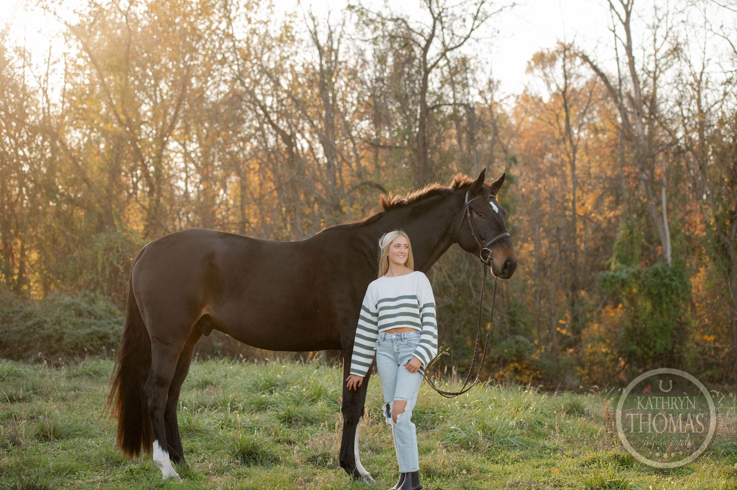 Autumn equestrian portrait with horse and companion against colorful fall foliage.