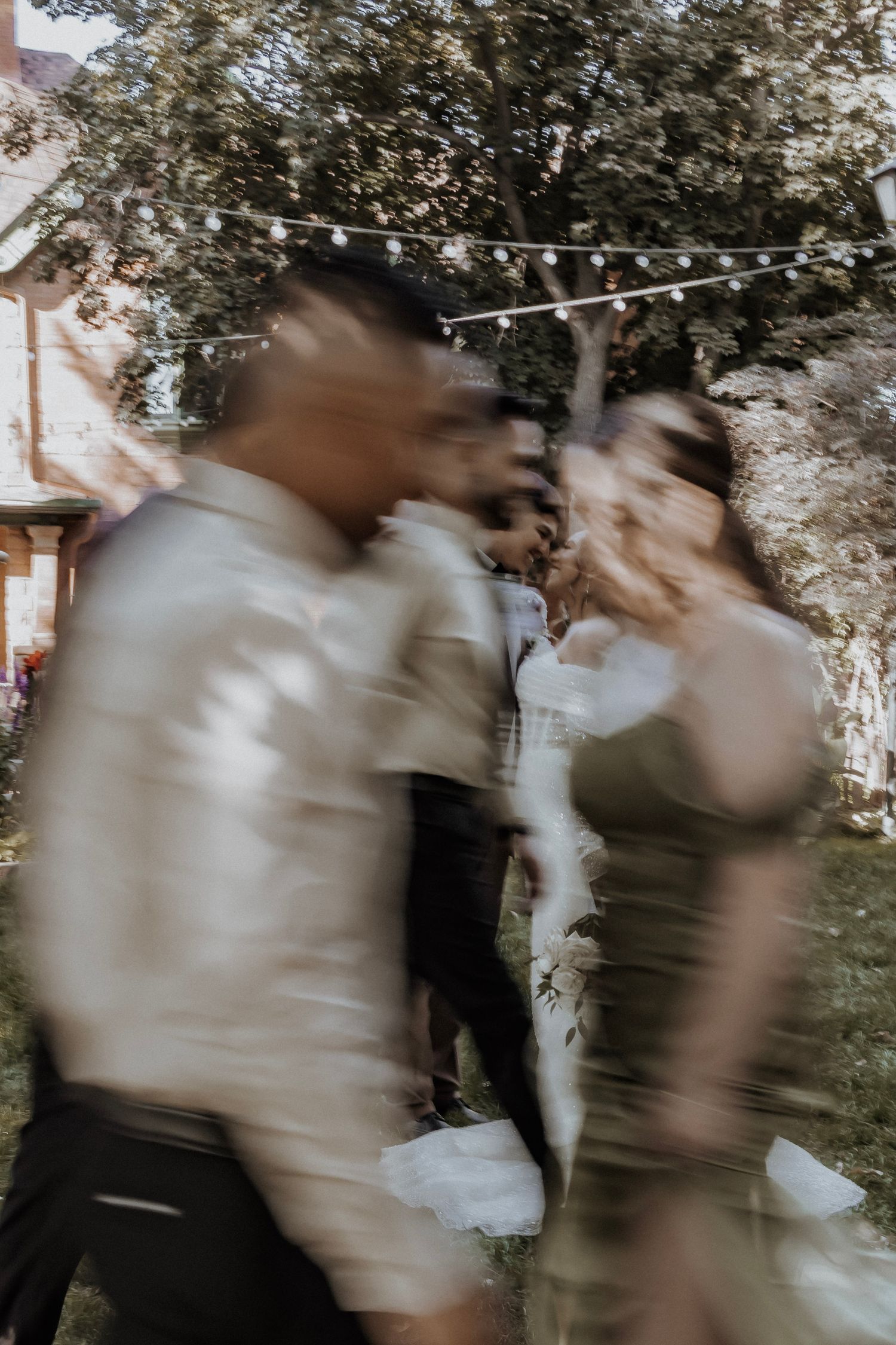 Bride and groom share a loving look as wedding party moves around them