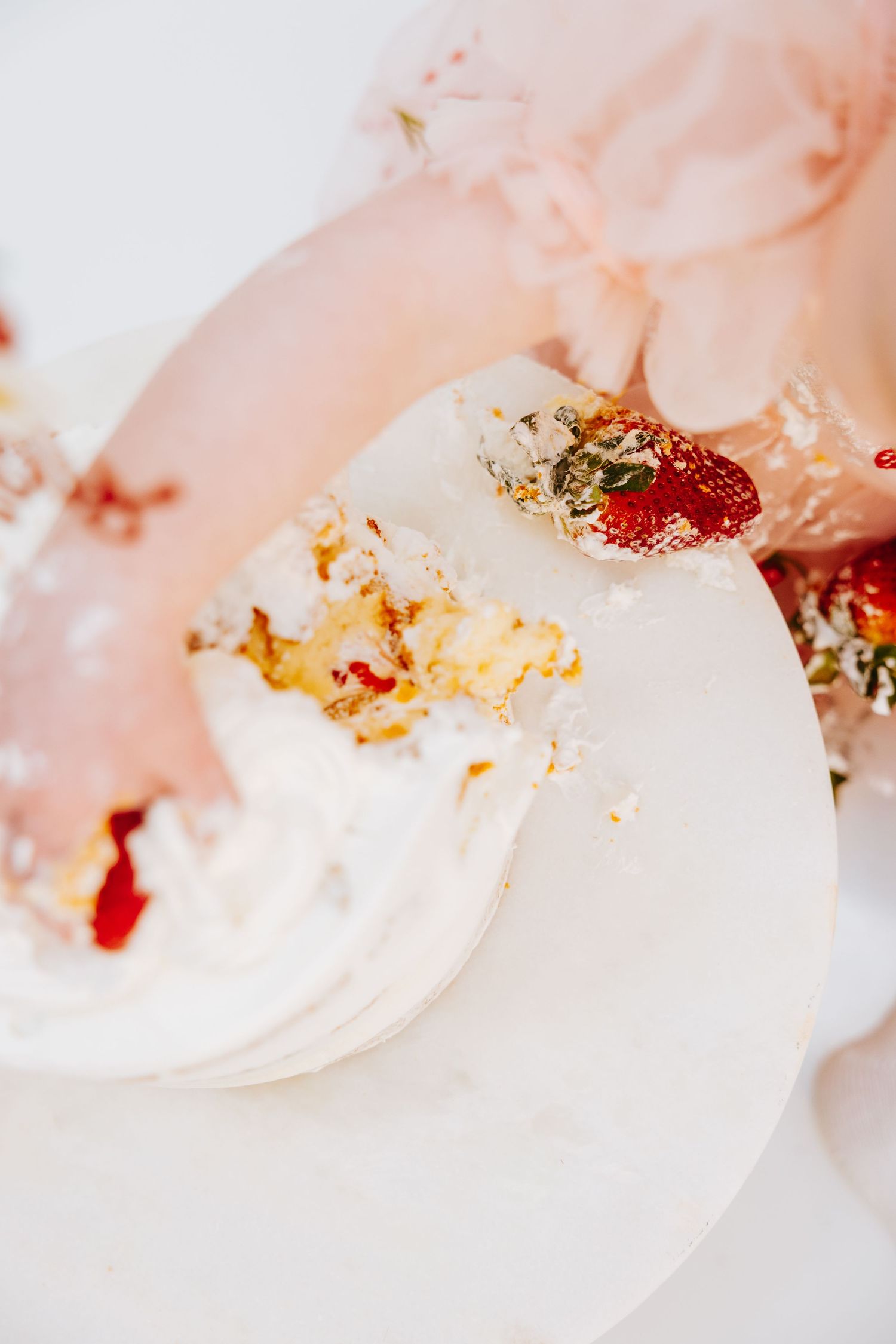 Close-up of smashed birthday cake with strawberry and cream details.