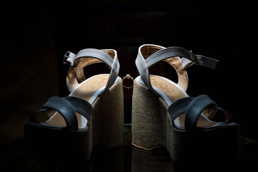 Elegant navy blue wedding shoes with straps displayed against dark background.