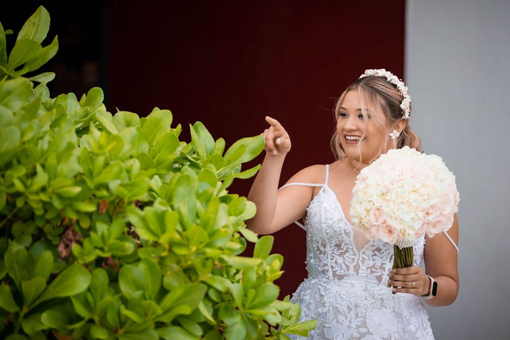 A white bouquet of flowers appears next to lush green foliage outdoors.