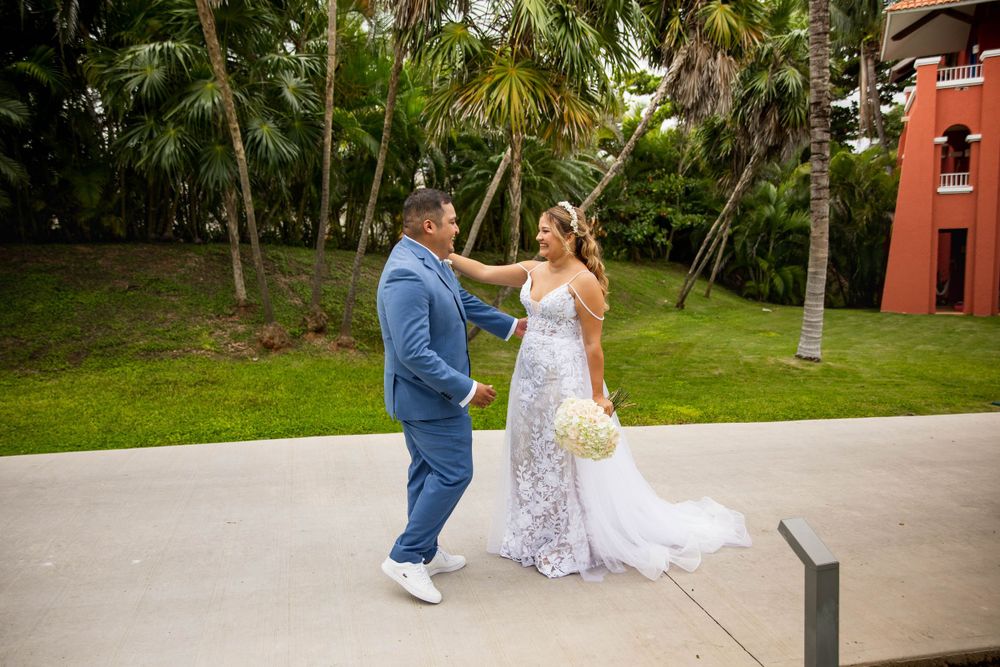 A couple sharing a candid moment on a palm tree-lined path at a tropical resort.