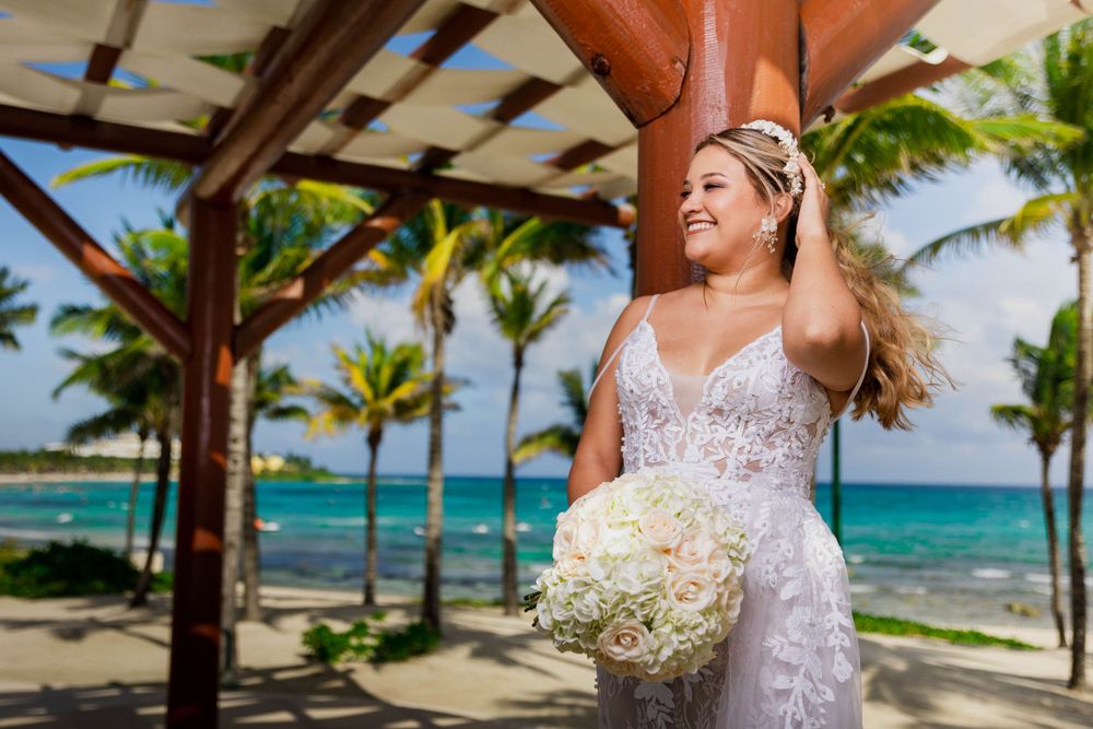 A joyful moment captured under a beach gazebo with turquoise ocean views.
