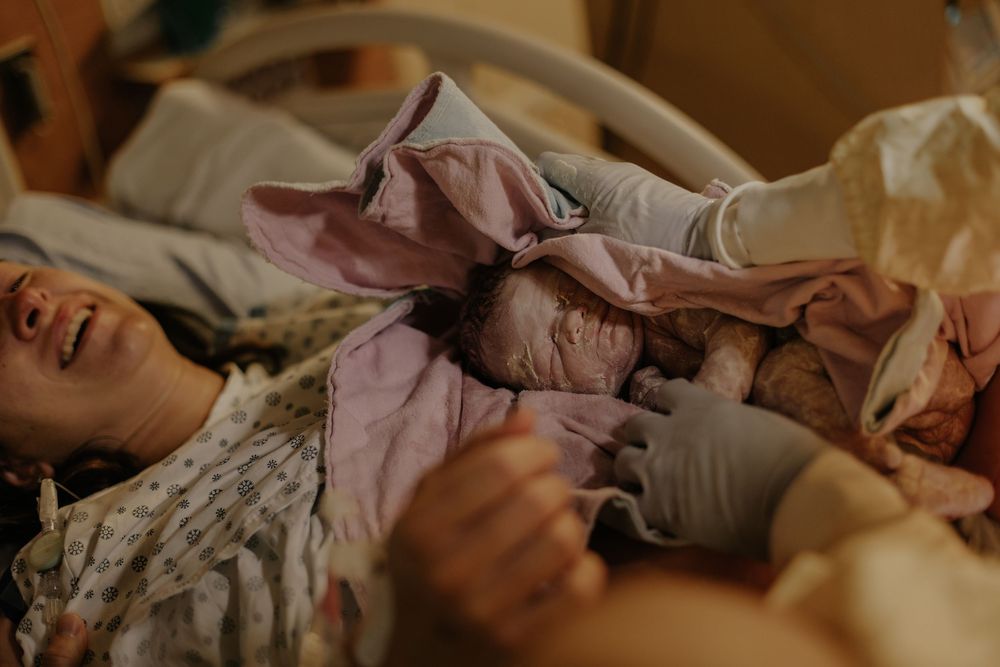 mom relieved and baby having the excess off vortex clean in ther face minutes after her birth