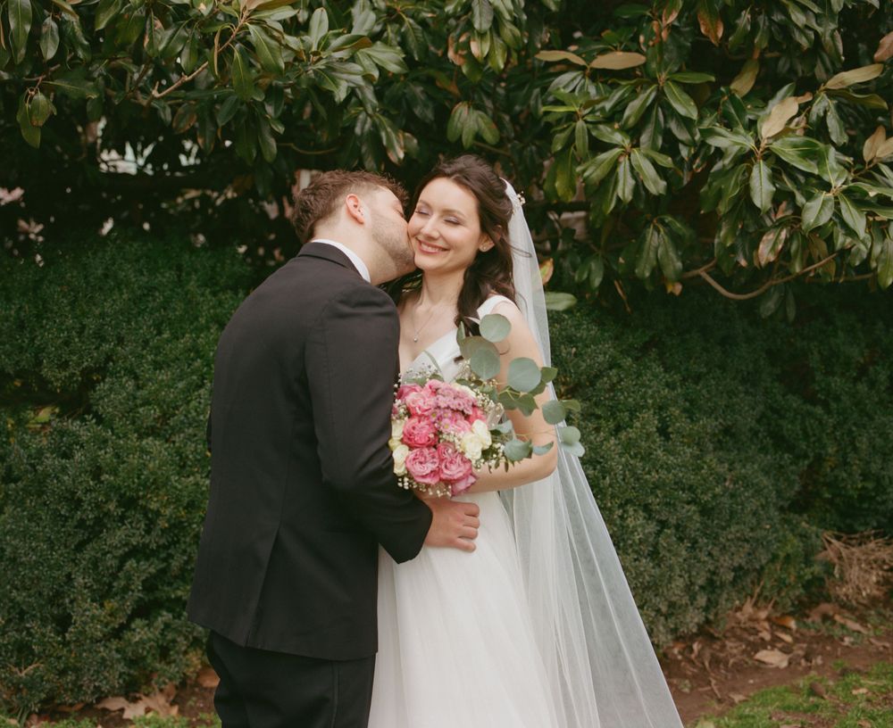 Groom kisses bride on the cheek