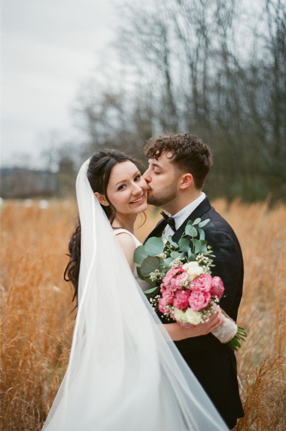 Groom kisses bride on the cheek