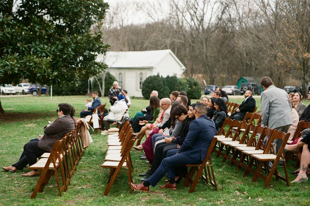 Guests of a wedding ceremony sitting in chairs