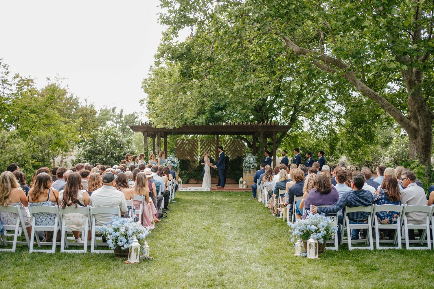 Couple shares first kiss at outdoor beach wedding ceremony at Lake Tahoe with mountain views.