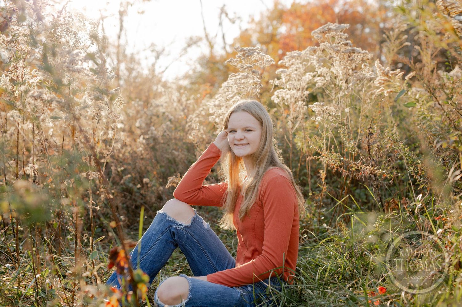 Casual outdoor portrait surrounded by autumn colors and dried wildflowers.