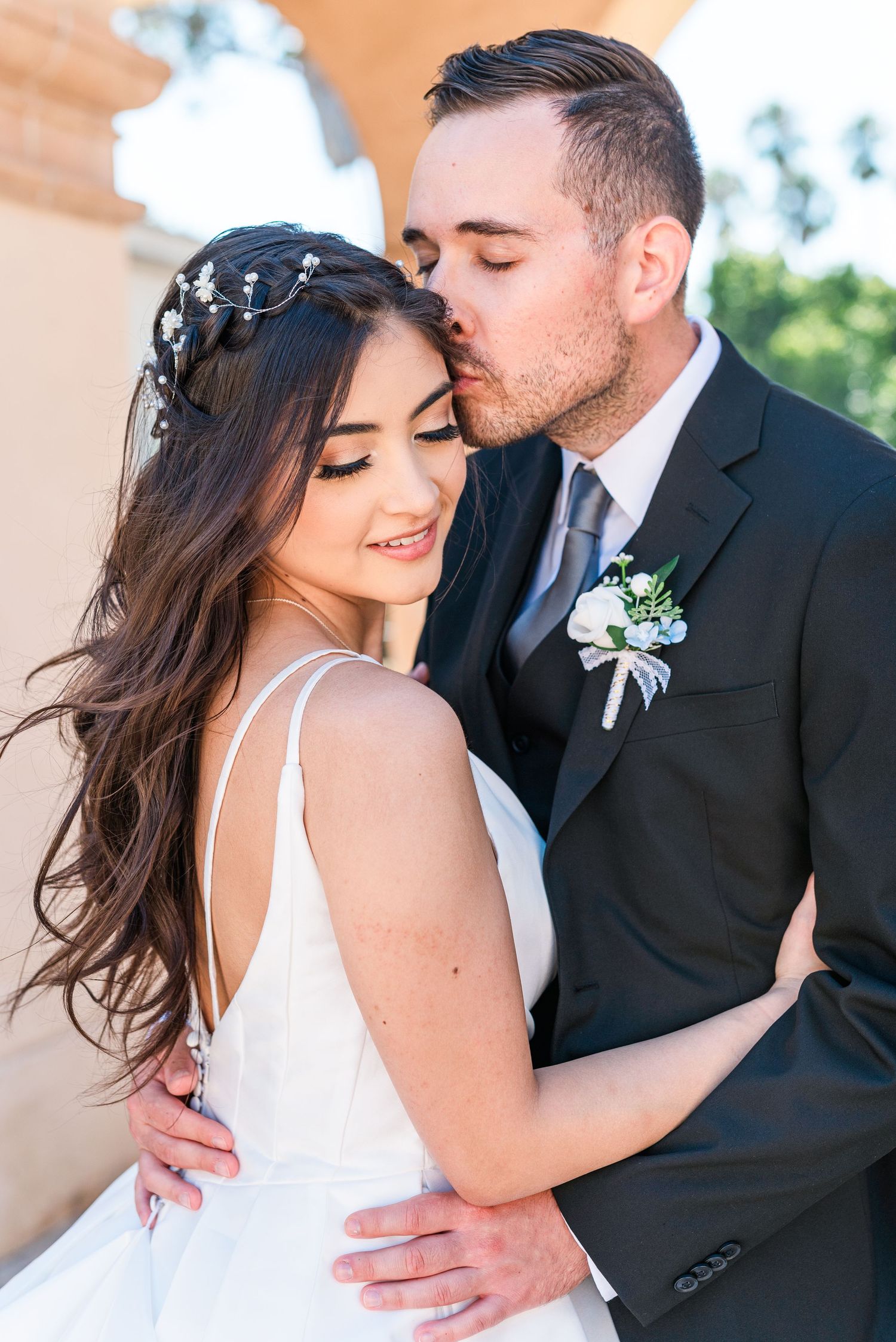 A tender romantic moment captured between a couple in formal attire.