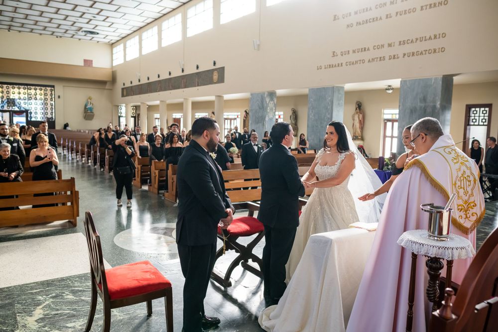 A wedding ceremony taking place in a modern church interior with high ceilings and natural lighting.