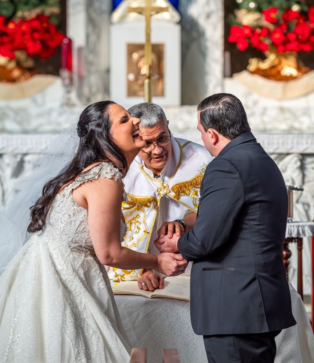 A joyful moment during a wedding ceremony at a church altar decorated for Christmas.