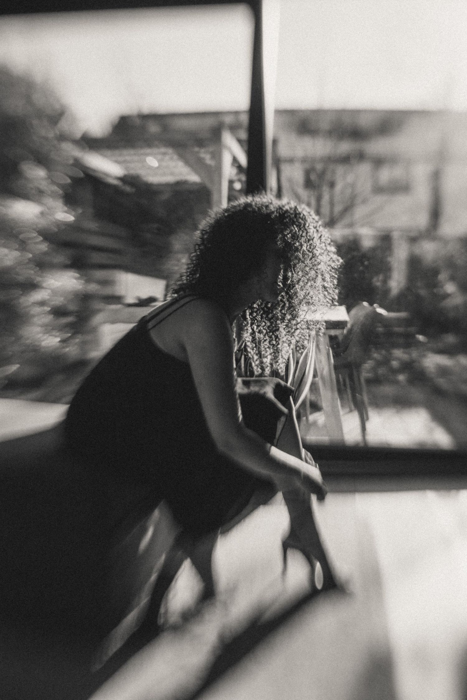 A black-and-white photograph capturing Priscilla’s elegant silhouette in a relaxed pose.