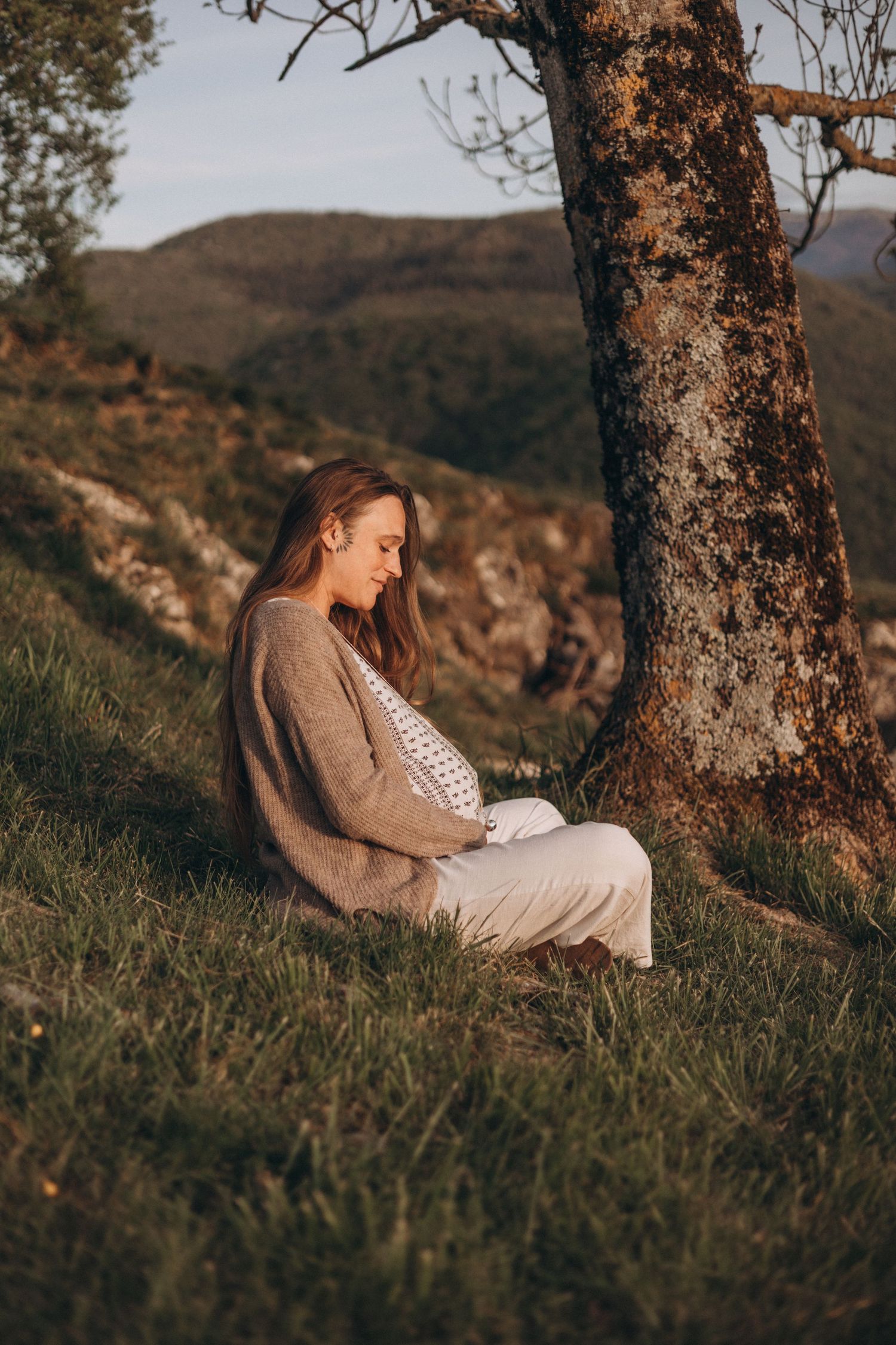 Artistic maternity photo with expecting mother holding dried flowers against her belly.