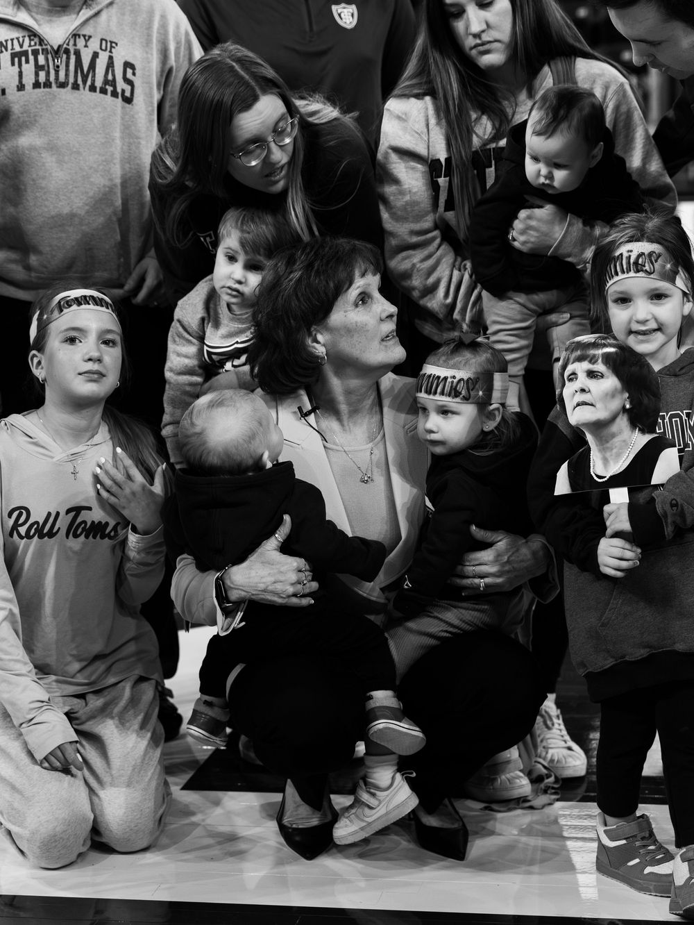 Black and white photograph showing a group gathered together in a casual setting, with adults and children interacting.