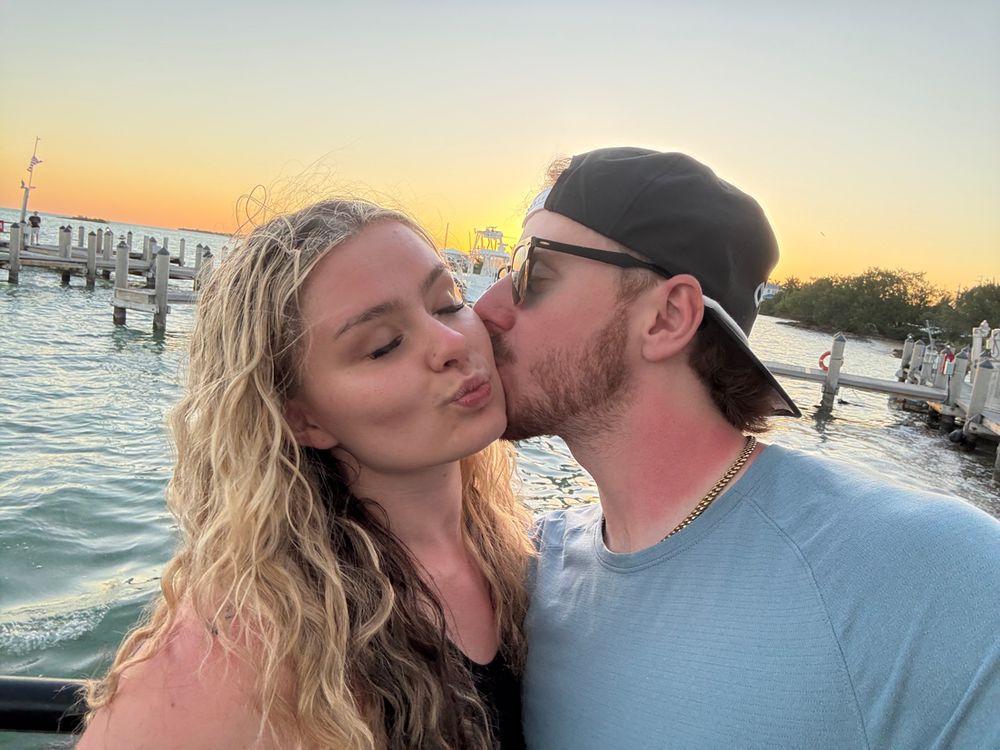 Couple sharing an intimate moment at sunset by the water.