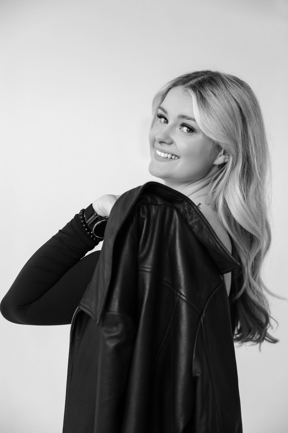 Black and white portrait series showing different poses in dark clothing against light background.