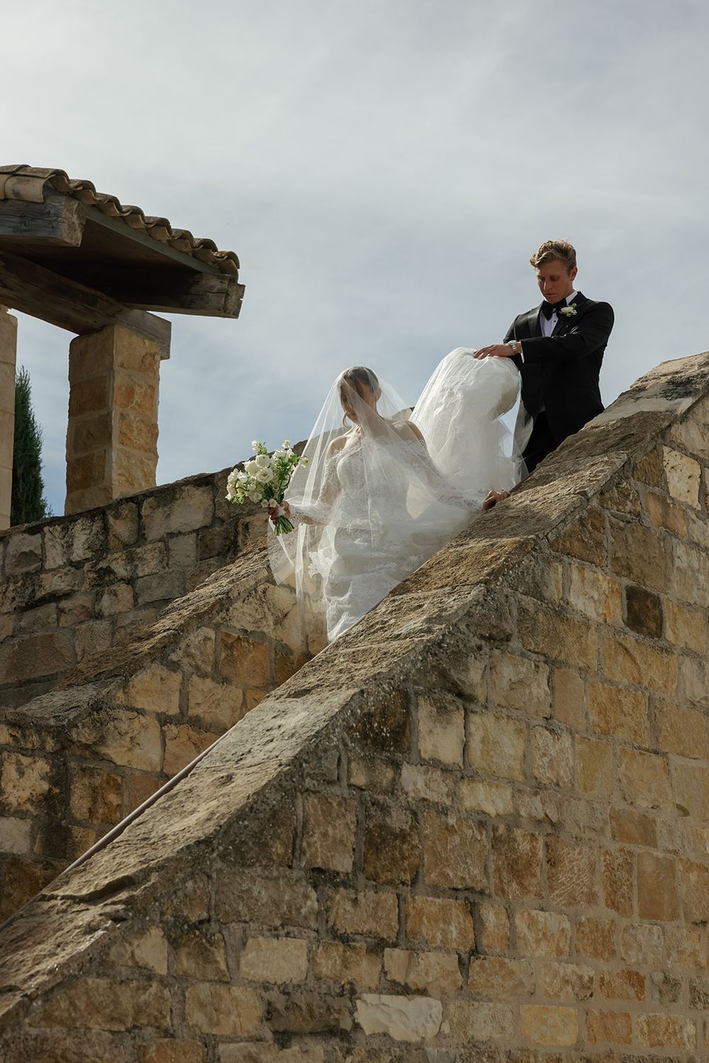 Wedding photography session on stone castle steps with flowing white dress and veil.
