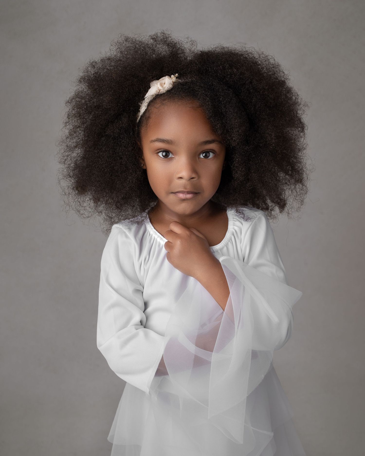 A warm portrait in white against an ornate mandala backdrop with macrame details and soft natural light.