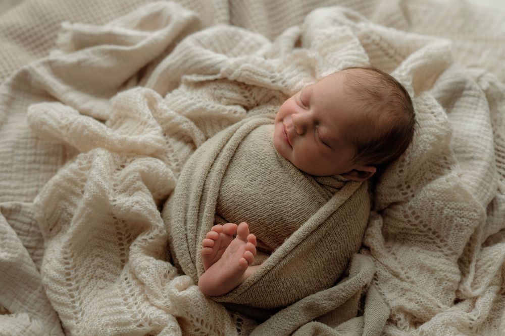 Sleepy newborn swaddled in blanket