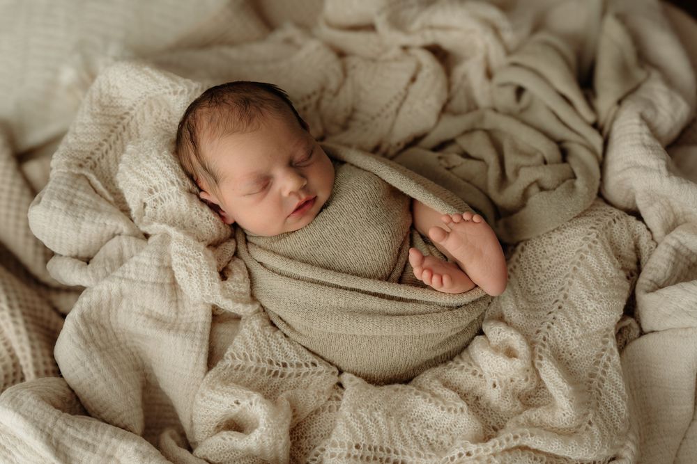 Sleepy newborn swaddled in blanket