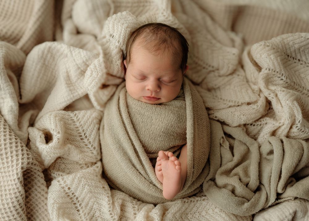 Sleepy newborn swaddled in blanket