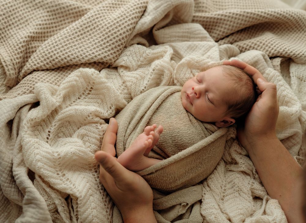 Sleepy newborn swaddled in blanket