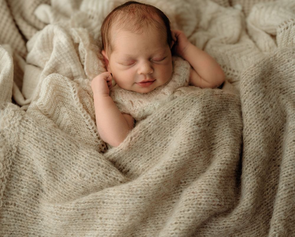 Sleepy new born covered in blanket