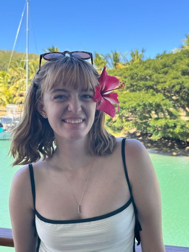 Tropical vacation portrait with a pink hibiscus flower against turquoise water background.