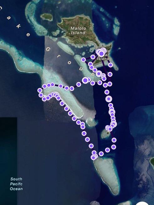Aerial map view of an island chain with purple GPS tracking points marking a route through the waters.