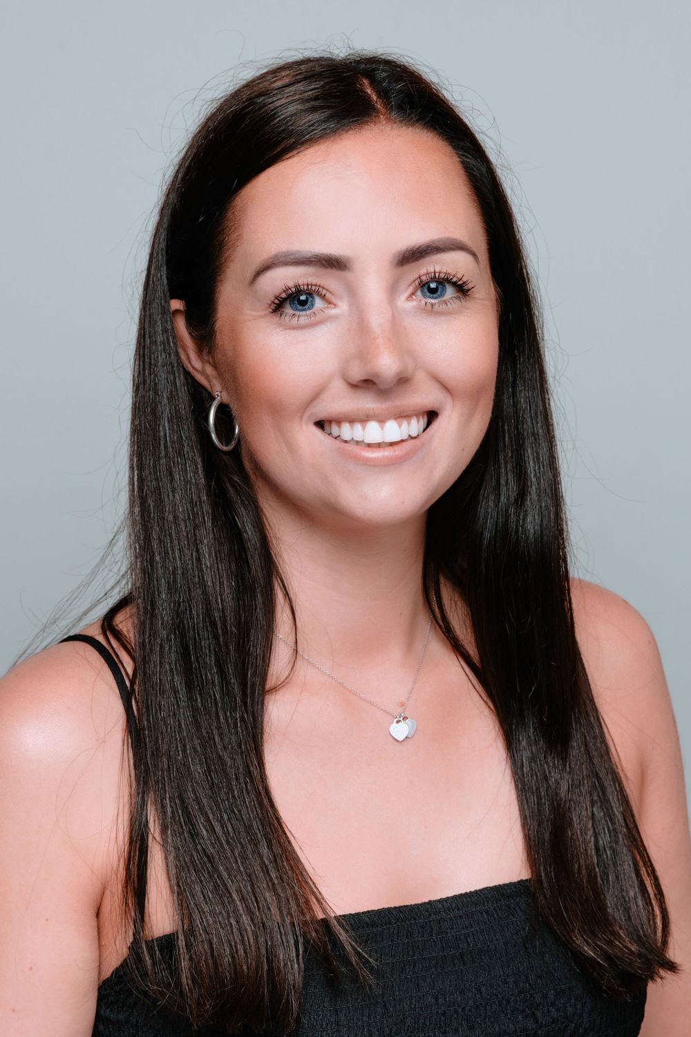 Portrait series showing joyful expressions wearing a black top and silver necklace against a light background.