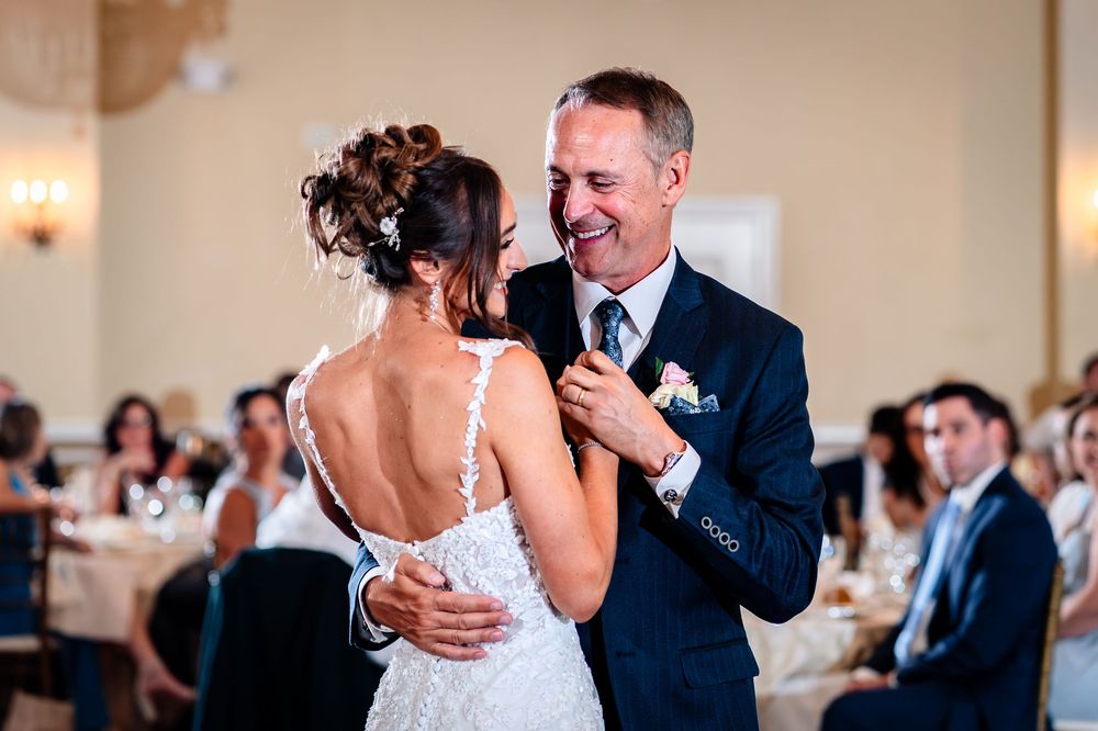 Couple shares their first dance together in an elegant ballroom setting.