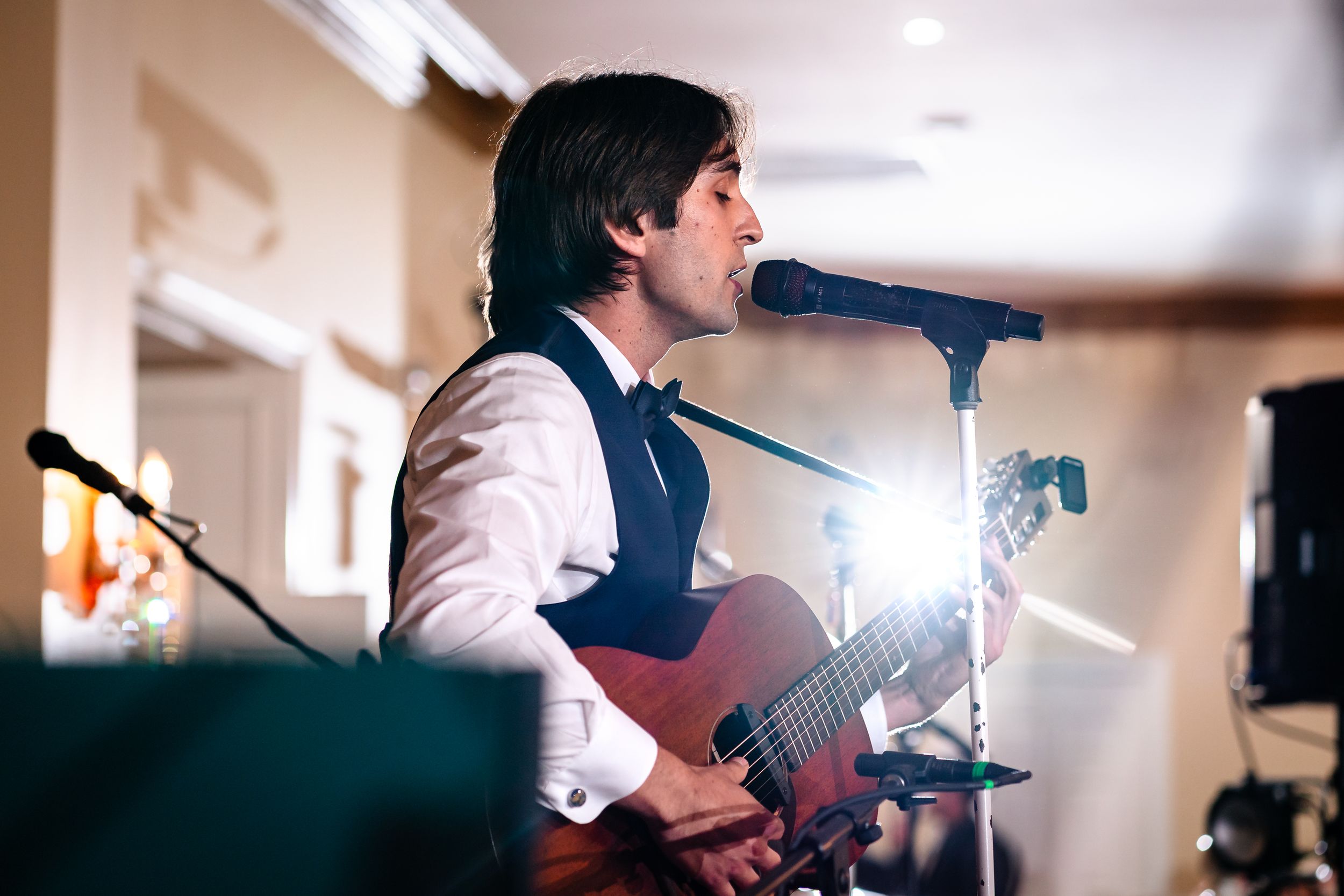 Musicians perform live music at an indoor wedding reception.