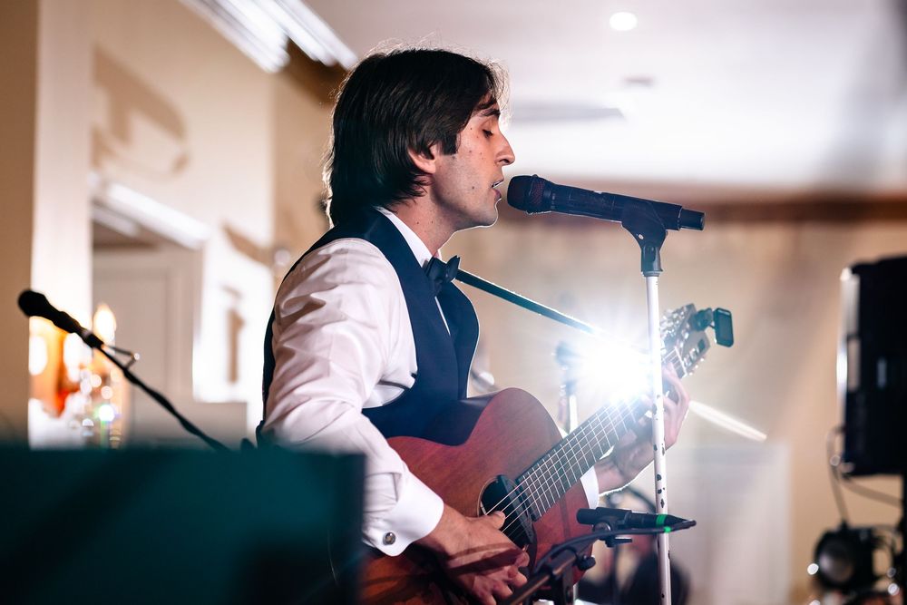 Musicians perform live music at an indoor wedding reception.